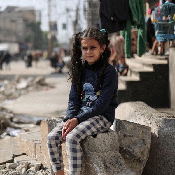 Die elfjährige Maha sitzt auf den Trümmern eines Hauses im Gazastreifen.