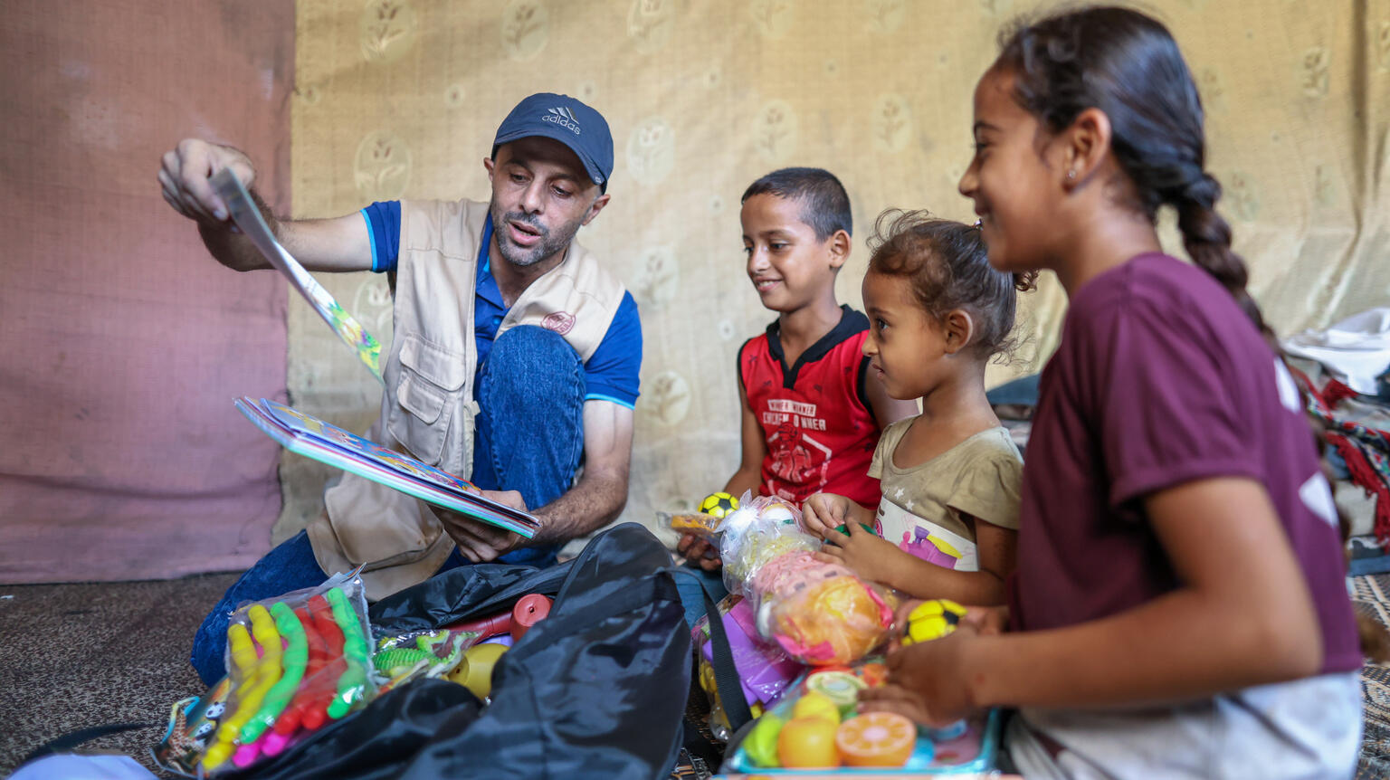 Ein Helfer verteilt Spielzeug an Kinder in Gaza.