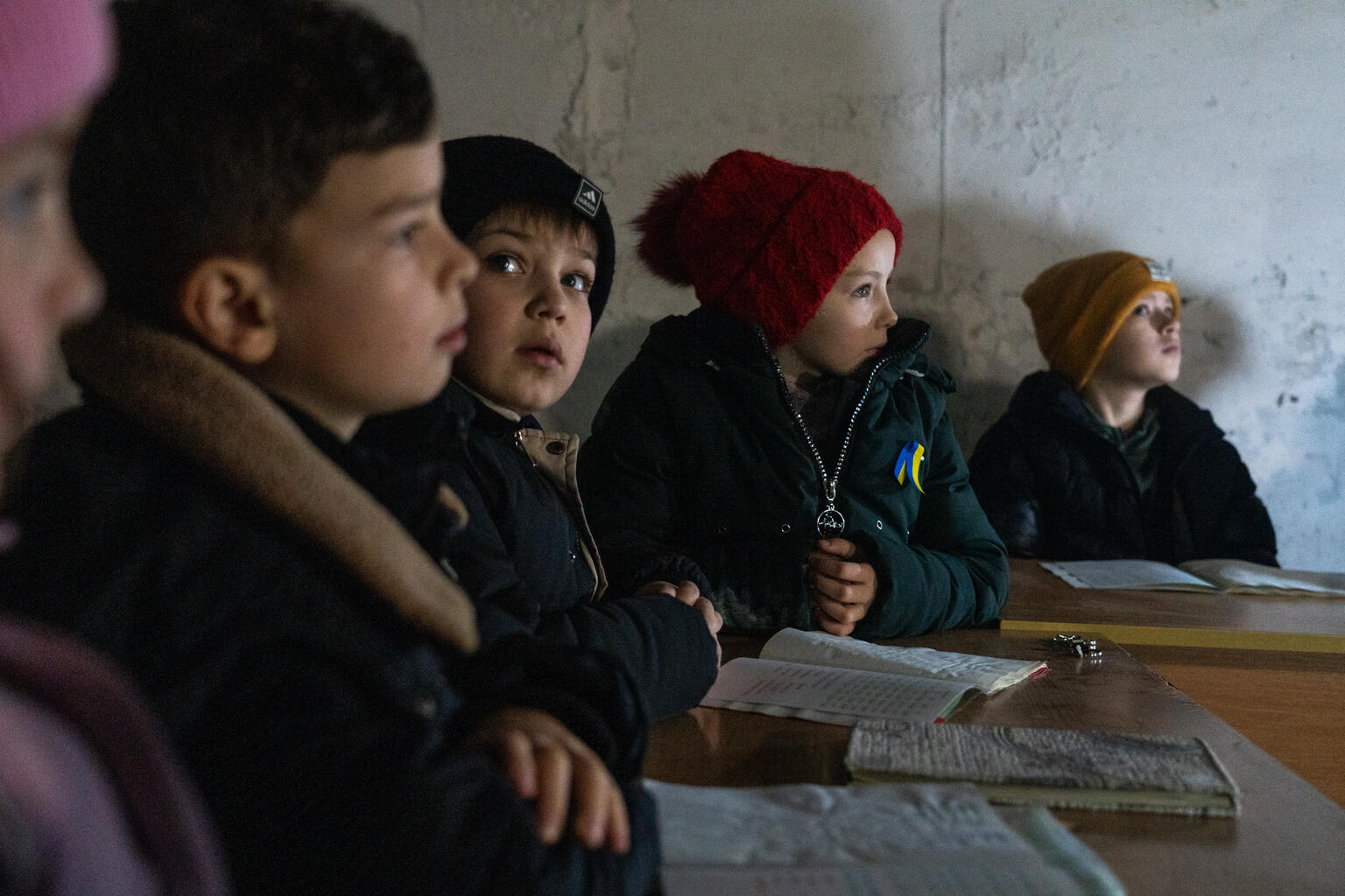 Kinder lernen in einem Schutzkeller, in dem ein Klassenraum eingerichtet wurde.